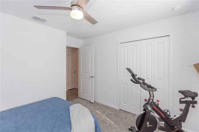 carpeted bedroom with ceiling fan and a closet