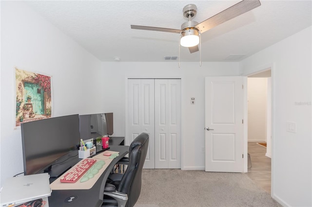 office featuring ceiling fan, light carpet, and a textured ceiling