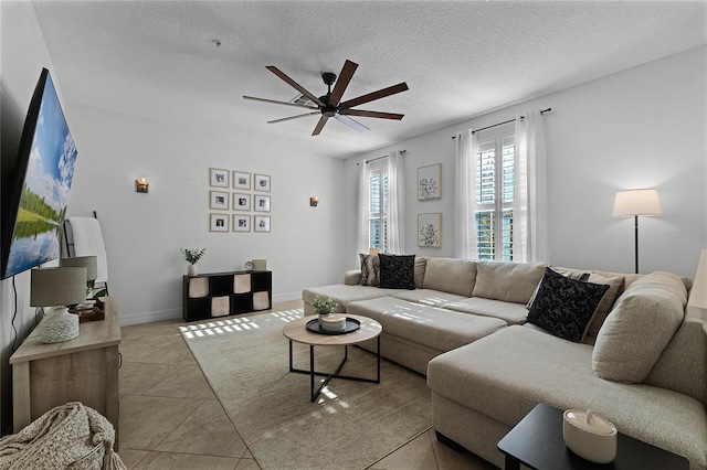 tiled living room with ceiling fan and a textured ceiling