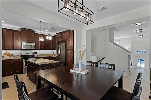 tiled dining room with a textured ceiling