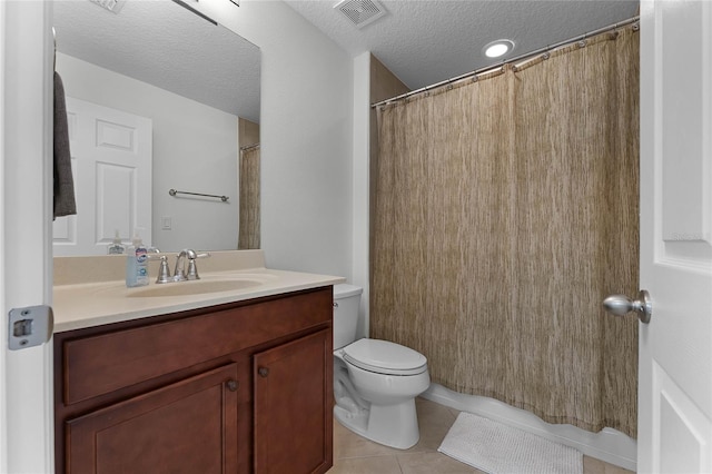 bathroom featuring tile patterned floors, vanity, toilet, and a textured ceiling