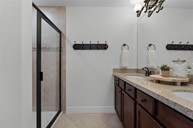 bathroom with tile patterned flooring, vanity, walk in shower, and a textured ceiling