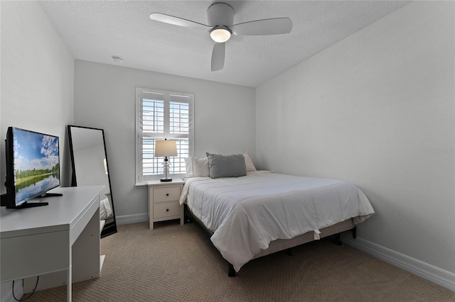 carpeted bedroom featuring ceiling fan and a textured ceiling