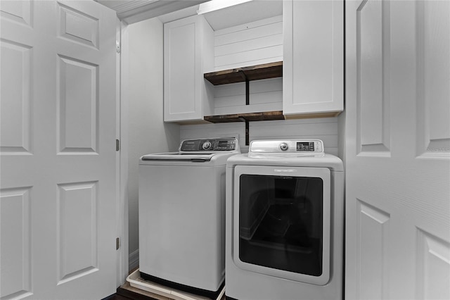 washroom with independent washer and dryer and cabinets