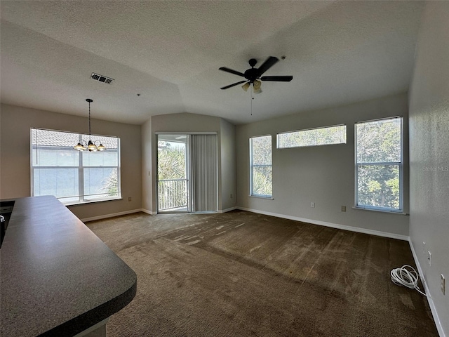 unfurnished living room with carpet floors, a textured ceiling, lofted ceiling, and ceiling fan with notable chandelier