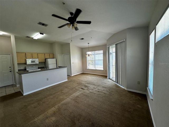 kitchen featuring vaulted ceiling, white appliances, hanging light fixtures, light brown cabinets, and dark colored carpet