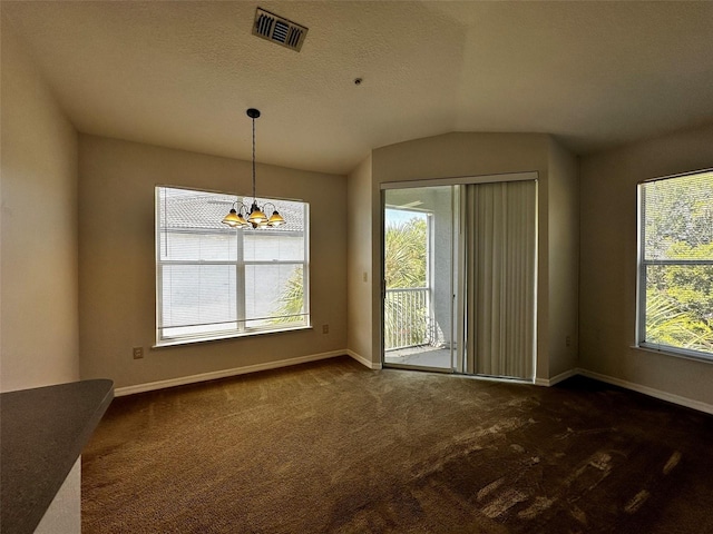 unfurnished dining area with a textured ceiling, lofted ceiling, dark carpet, and a notable chandelier