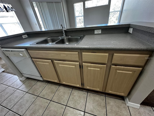 kitchen featuring a healthy amount of sunlight, sink, white dishwasher, and light tile patterned flooring