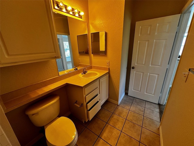 bathroom with toilet, tile patterned flooring, and vanity