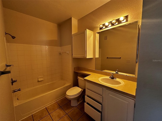 full bathroom featuring toilet, tiled shower / bath combo, tile patterned floors, and vanity