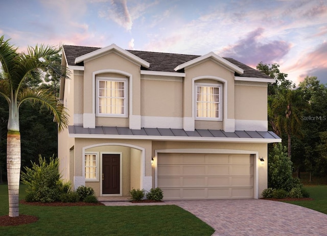 view of front of home with a yard and a garage