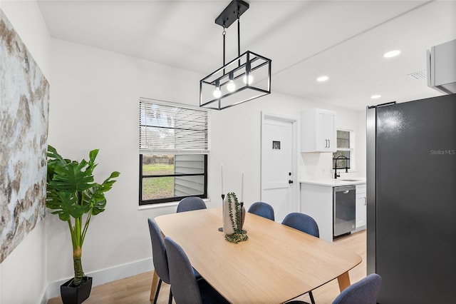 dining space featuring sink and light hardwood / wood-style flooring