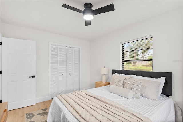 bedroom with ceiling fan, light wood-type flooring, and a closet