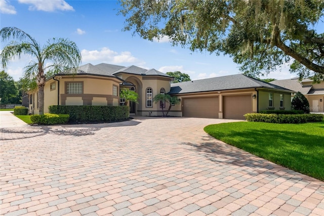 mediterranean / spanish house with a garage and a front yard