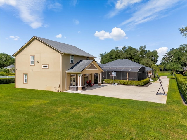 back of property with a lawn, glass enclosure, and a patio