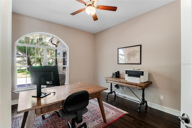 office area with plenty of natural light, ceiling fan, and dark wood-type flooring