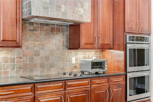 kitchen with backsplash, black electric stovetop, stainless steel double oven, and extractor fan