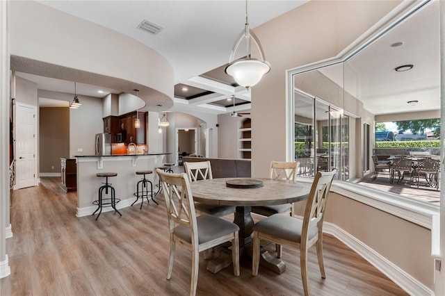 dining room featuring beamed ceiling, light hardwood / wood-style flooring, and coffered ceiling