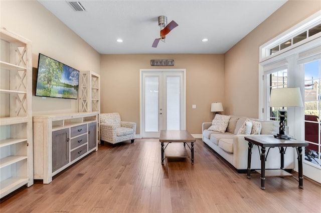 living room with ceiling fan, french doors, and light hardwood / wood-style flooring