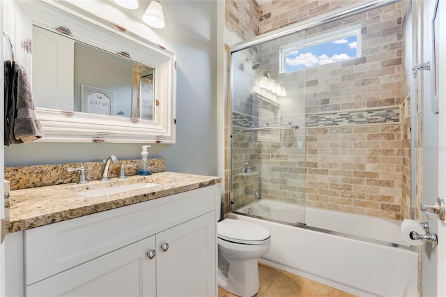 full bathroom with shower / bath combination with glass door, tile patterned floors, vanity, and toilet