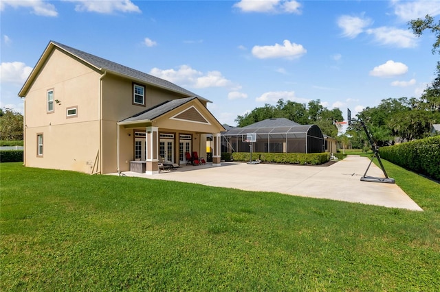 back of property with a lawn, glass enclosure, and a patio