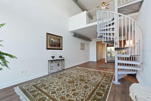 staircase featuring hardwood / wood-style flooring and a high ceiling