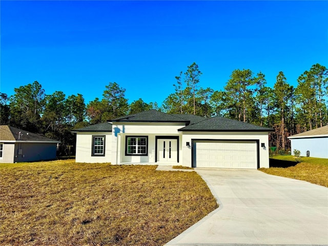 view of front of house with a garage, french doors, and a front lawn