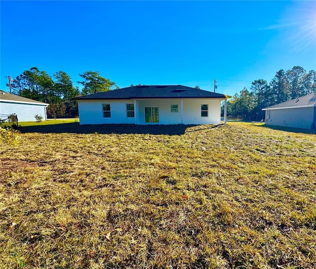 back of house featuring a lawn