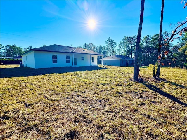 rear view of house featuring a yard