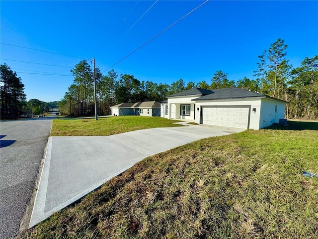 view of front of house featuring driveway, stucco siding, an attached garage, and a front yard