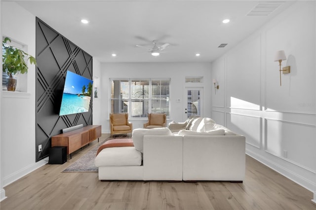 living room featuring ceiling fan and light hardwood / wood-style floors