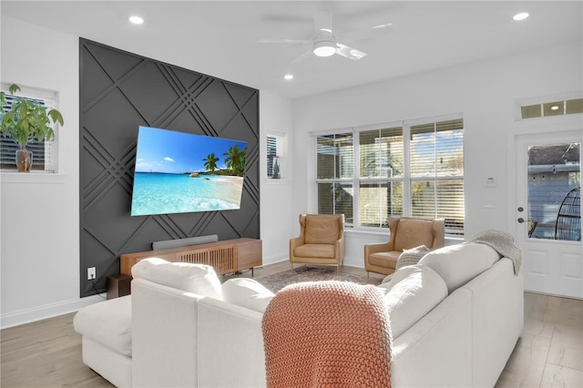 living room with light hardwood / wood-style flooring and ceiling fan