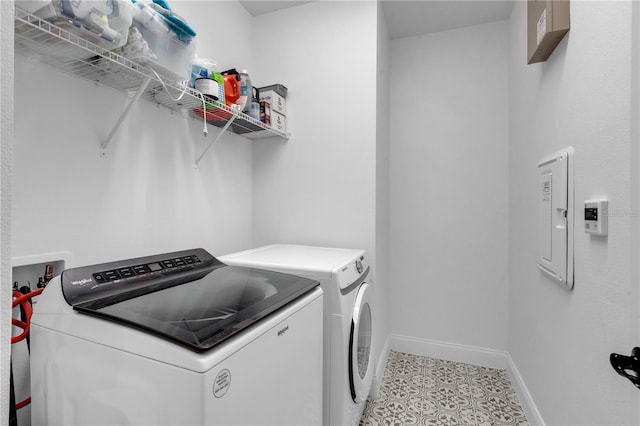 laundry room with washer and clothes dryer and light tile patterned floors