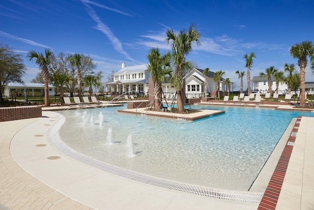 view of swimming pool with pool water feature and a patio