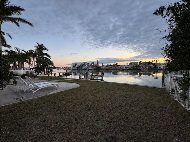 view of dock featuring a water view and a lawn