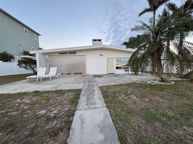 back of house with a yard and a patio area