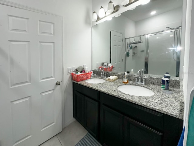 bathroom with a shower with shower door, tile patterned floors, and vanity