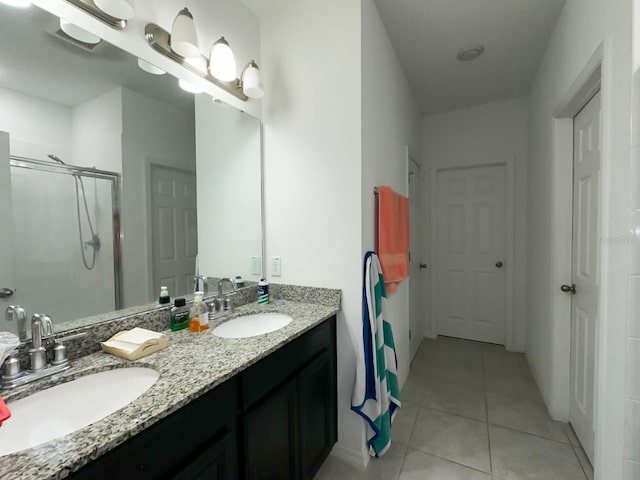 bathroom with a shower, vanity, and tile patterned flooring