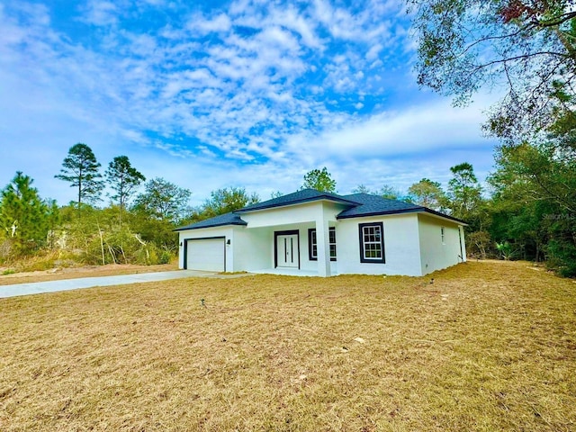 view of front of home with a front lawn and a garage