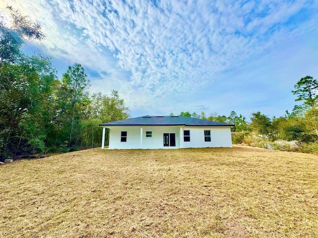 rear view of property with a yard