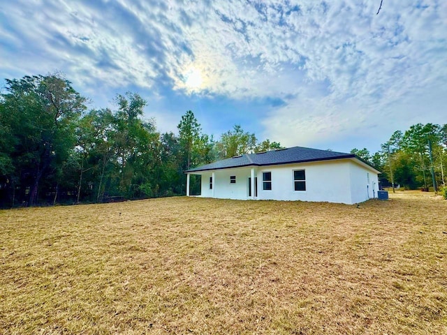 rear view of property featuring a lawn