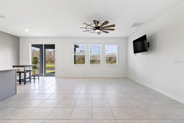 unfurnished room featuring ceiling fan, light tile patterned floors, and plenty of natural light