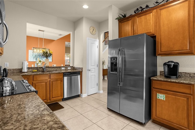 kitchen with decorative light fixtures, stainless steel appliances, light tile patterned floors, and sink