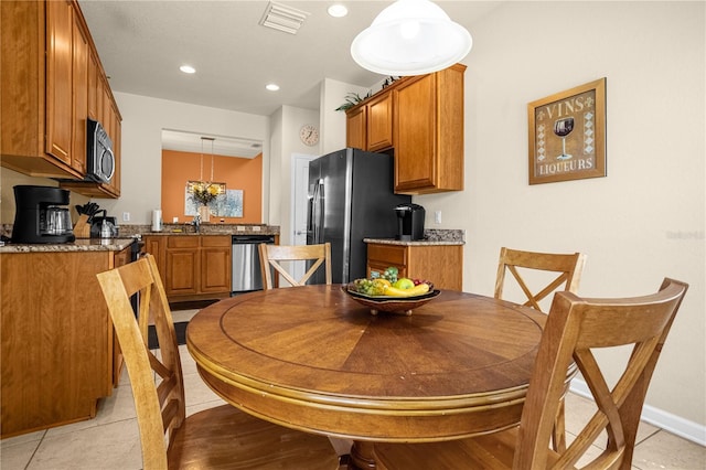 tiled dining area featuring sink and a chandelier