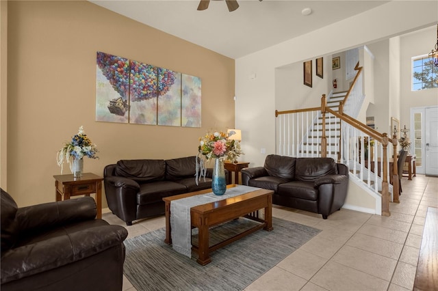 tiled living room featuring ceiling fan with notable chandelier