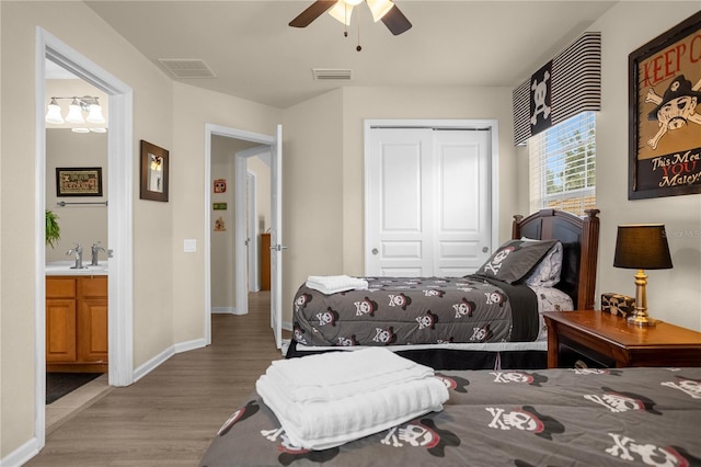 bedroom with ceiling fan, sink, connected bathroom, light hardwood / wood-style floors, and a closet