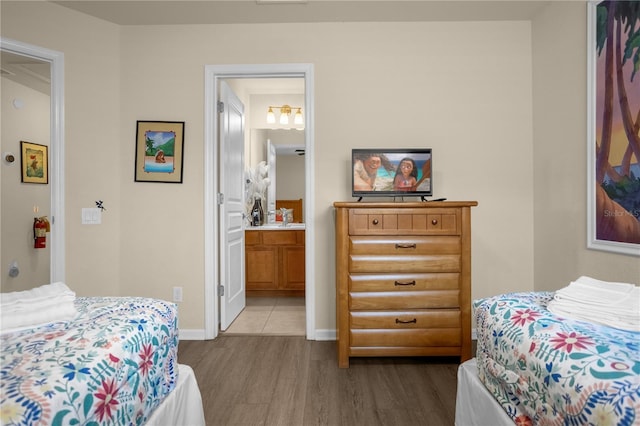 bedroom with wood-type flooring and connected bathroom