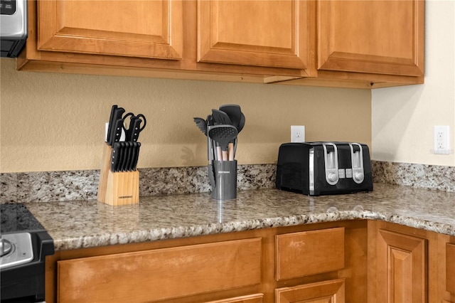 room details featuring range with electric stovetop and light stone countertops