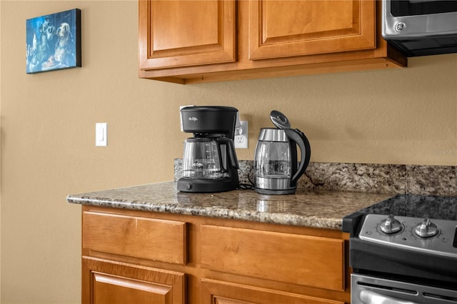 interior space featuring stainless steel range with electric cooktop and dark stone countertops