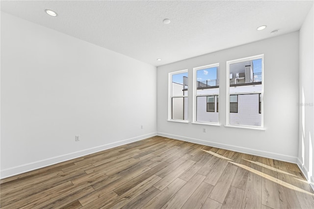 empty room featuring wood-type flooring and a textured ceiling